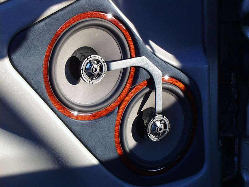 Alcantara Suede inserts and custom rosewood trim-rings were made to tie this highlighted speaker set-up into the factory look. Also notice the tweeter brackets show no screws or wires.