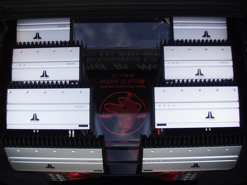 A birds-eye view shows the JL Audio amplifiers cascading down. There are four 300/2 (one for each door) and four 1000/1 (one for each sub). The .75" custom plexiglas allows views inside.