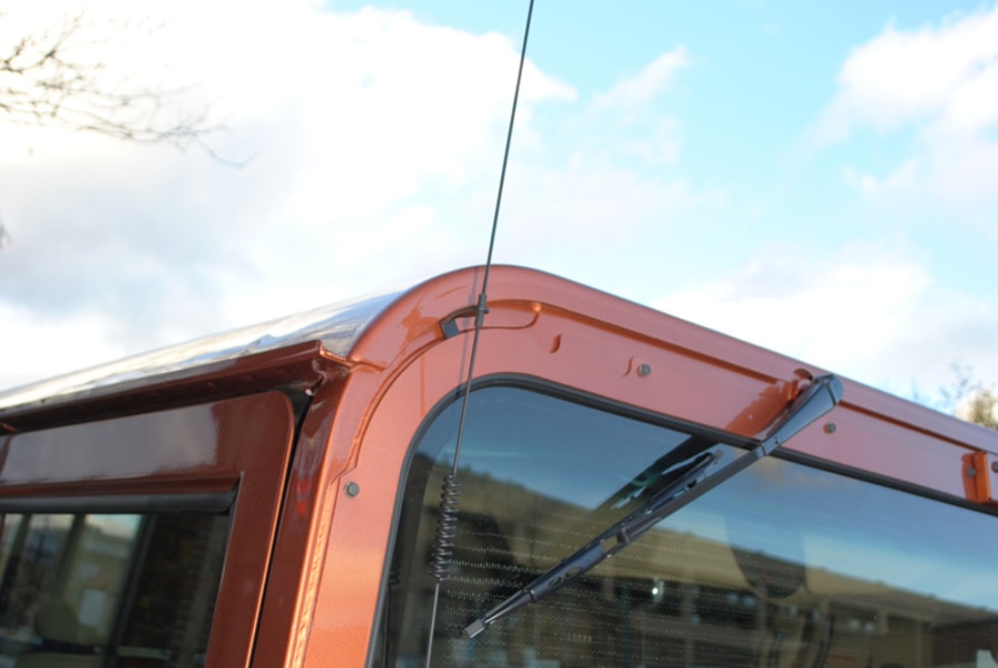 A windshield mount CB antenna was mounted low to avoid interference from the defroster elements embedded in the factory glass. Also note the little holder on top, to keep it from hitting the car.