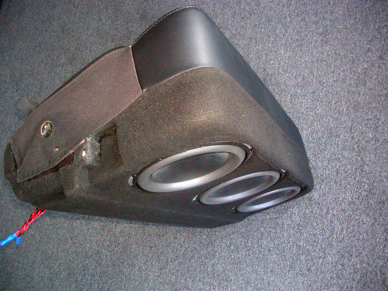 The bigger left rear seat was converted to a subwoofer enclosure for the three 10" down firing woofers. The original seat cover was used for that factory look, but a carpet extension was sewn on the bottom of both seatcovers.