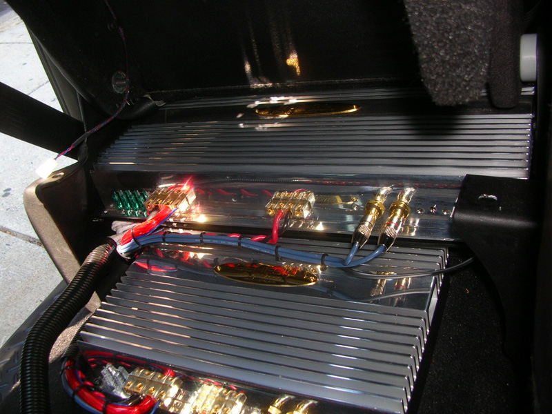 A close-up look at the shiny Genesis amplifiers. Everything is mounted with custom brackets for serviceability. The Focal Crossblock sits on top of the amplifiers (it's pulled out for better view of the amps)